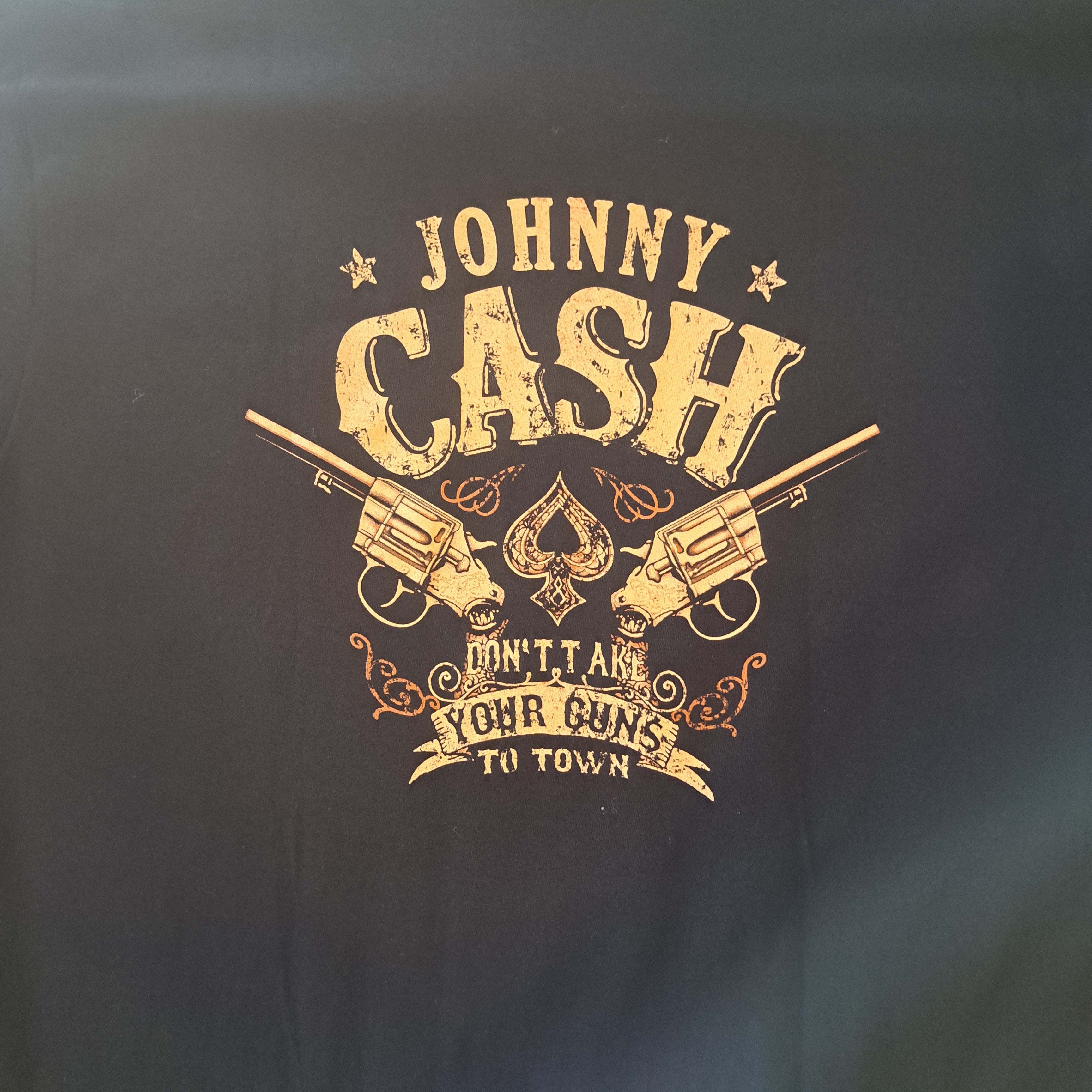 Black t-shirt with gold graphic and text of Johnny Cash design.